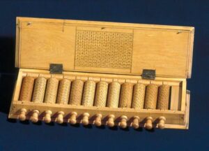 Wooden Napier's Bones tool for manual calculations.